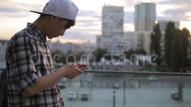 帅气亚洲学生男子打字智能<strong>手机</strong>市区夜光通讯技术4G接收短信